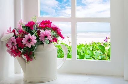 Bouquet of artificial flowers in a window to look through the window at the sea. relaxation concept